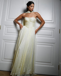 Draped in yellow chiffon silk, ruching that whispers elegance and grace