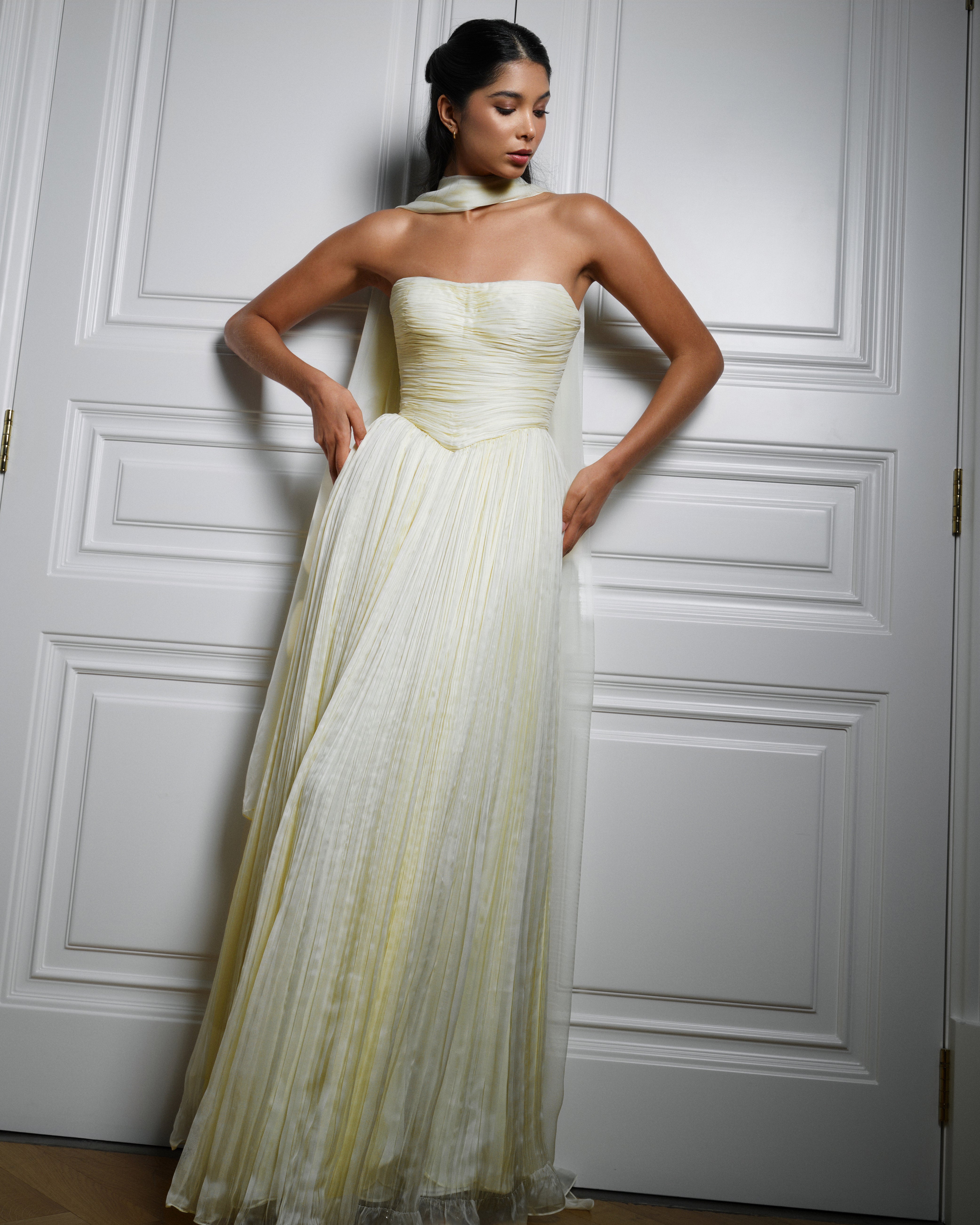 Draped in yellow chiffon silk, ruching that whispers elegance and grace